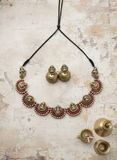Terracotta necklace with red stones details and matching earrings on a textured surface