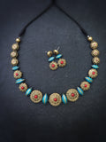 Terracotta Necklace and earrings set with decorative beads on a dark background