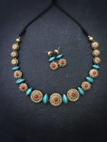 Terracotta Necklace and earrings set with decorative beads on a dark background