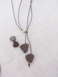Terracotta Necklace with heart-shaped pendants on a textured white background