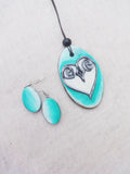 Terracotta heart-shaped necklace and earrings on a light gray background