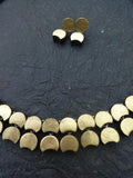 Gold Terracotta necklace and earrings on a dark textured surface
