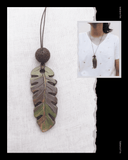 Leaves Terracotta necklace on a white fabric background with a person wearing it inset.