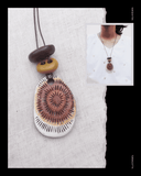 Handmade necklace with circular Terracottapendant on a textured white background