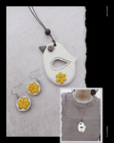 White bird-shaped Terracotta pendant with yellow flowers on a gray fabric background