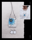 Jewelry set with a Terracotta pendant and earrings on a textured white surface.