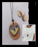 Heart-shaped Terracotta pendant and earrings on a textured fabric background with a person wearing the necklace.