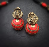 Pair of red and gold terracotta  earrings on a dark surface