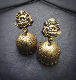 Pair of terracotta  earrings on a dark textured surface