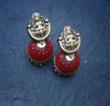 Pair of red terracotta  earrings with gold tops on a blue textured background