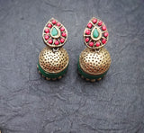 Pair of gold terracotta earrings with green and red stones on a gray background